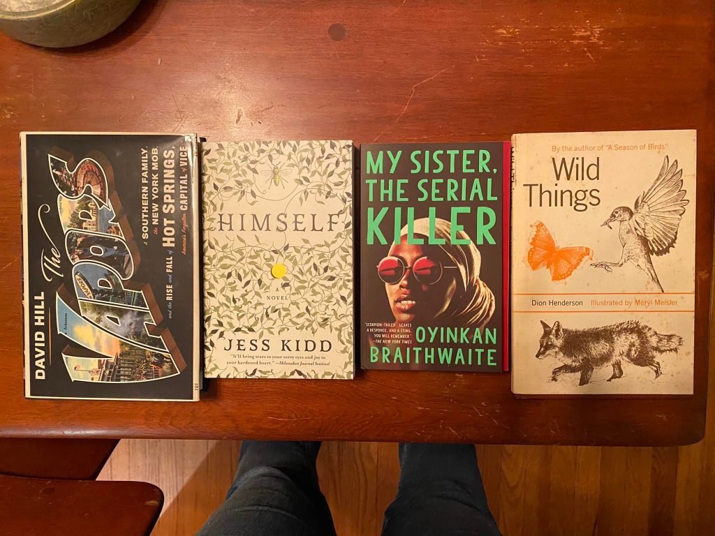 Four books on a coffee table: The Vapors, Himself, My Sister the Serial Killer, and Wild Things